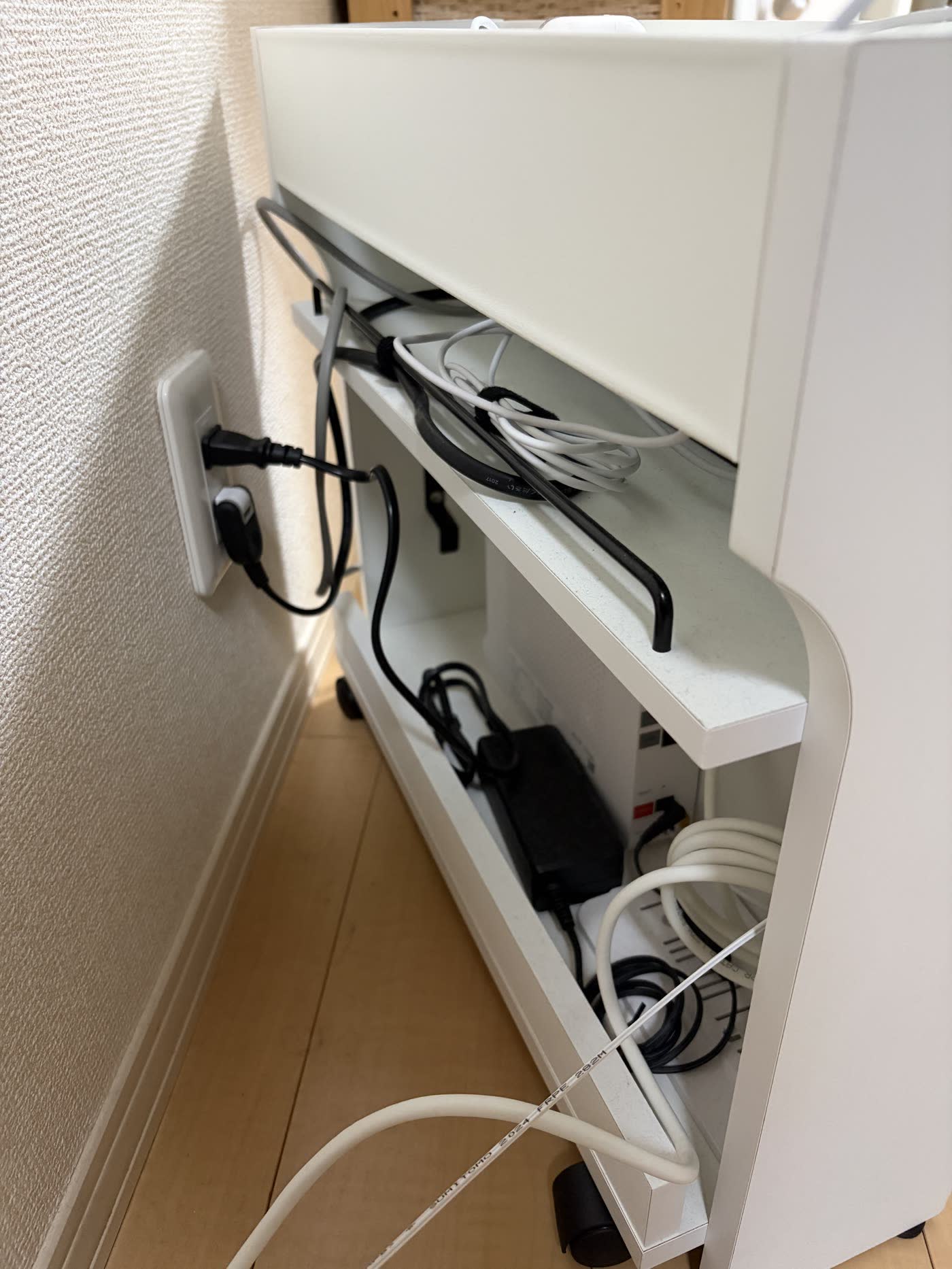 収納ボックスを横から見たところ。電源タップとACアダプタ、余ったケーブルが中に収まっている